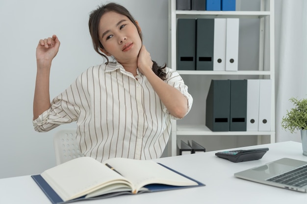 síndromes de oficina mujer masajeando el dolor de cuello debido al trabajo y usando un compuesto digital de computadora de una columna enfocada de dolor de cuello y dolor de hombro síntomas lesiones atención médica miositis médica