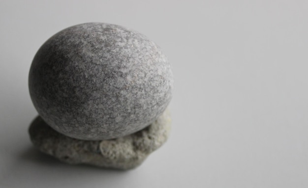 Foto single zen stone on white surface at a side of image foto de estoque para fundos