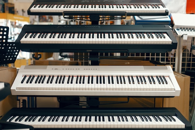 Foto sintetizadores digitais em vitrine na loja de música, vista de perto, ninguém. variedade em loja de instrumentos musicais, equipamentos profissionais para músicos e performers