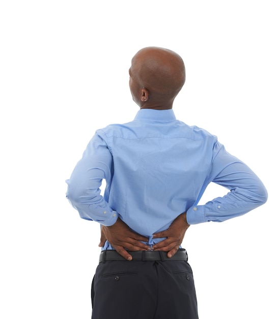 Sintiendo los efectos de estar sentado todo el día Foto de estudio retrovisor de un hombre de negocios afroamericano sosteniendo su espalda baja con dolor