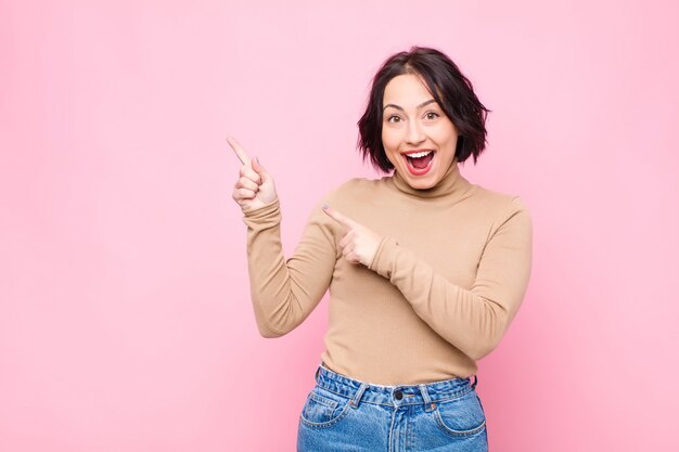 sintiéndose alegre y sorprendido, sonriendo con una expresión de asombro y señalando a un lado