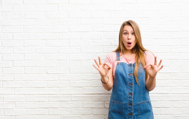 sintiéndose sorprendido, asombrado y sorprendido, mostrando aprobación haciendo un buen signo con ambas manos