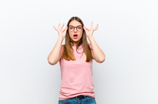 Foto sintiéndose sorprendido, asombrado y sorprendido, sosteniendo gafas con una mirada asombrada e incrédula