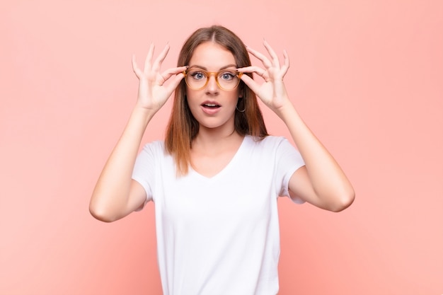 sintiéndose sorprendido, asombrado y sorprendido, sosteniendo gafas con una mirada asombrada e incrédula