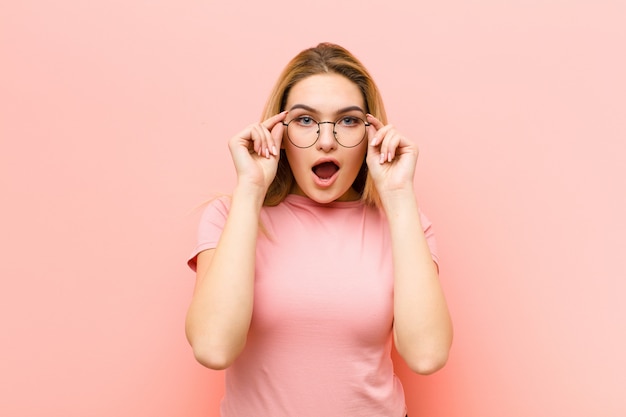 sintiéndose sorprendido, asombrado y sorprendido, sosteniendo gafas con una mirada asombrada e incrédula