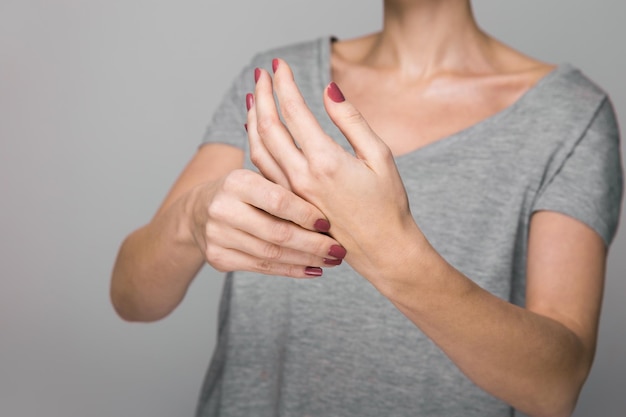 Sintomas da doença de Parkinson Close de tremor apertando as mãos de mulheres de meia-idade com doença de Parkinson Saúde mental e distúrbios neurológicos