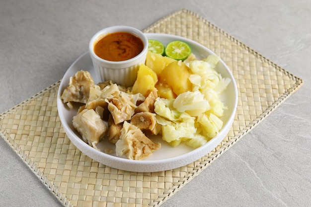 Siomay Bandung. Fischfrikadellen mit Kartoffel-Kraut-Rolle, serviert mit Erdnusssaucen