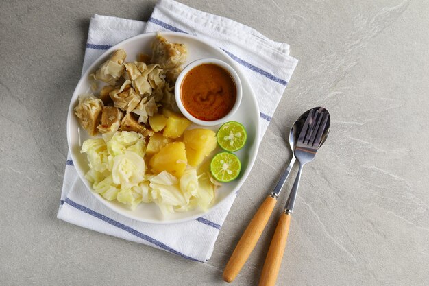 Siomay Bandung. Fischfrikadellen mit Kartoffel-Kraut-Rolle, serviert mit Erdnusssaucen