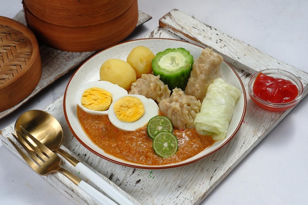 Siomay o Somai, bola de masa de pescado al vapor de Indonesia con verduras servidas en salsa de maní.