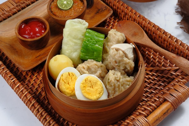 siomay ou Somai, bolinho de peixe indonésio cozido no vapor com legumes servidos em molho de amendoim.