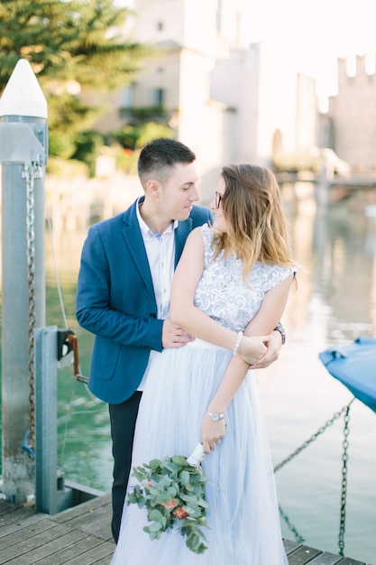 Sirmione, Lago di Garda, Italia. Encantadora pareja de enamorados abrazándose y besándose en el puente en Sirmione