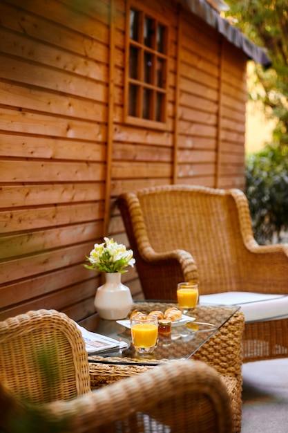 Se sirve una mesa en el patio para el desayuno y está decorada con un jarrón de flores.