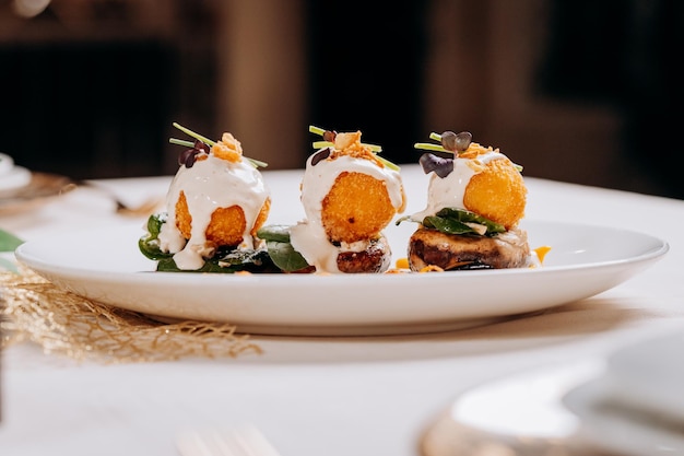 Foto se sirven bolas de queso frito sobre una almohada de champiñones y berenjenas listas para comer menú del restaurante