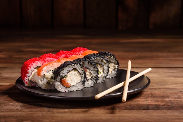 Se sirven varios tipos de sushi. Rodillo con salmón, aguacate, pepino. Menú de sushi Comida japonesa.