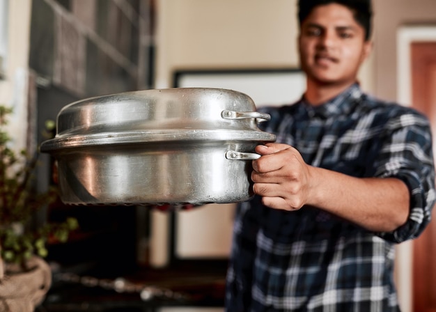 Foto sirviendo un festín primer plano de un hombre irreconocible sosteniendo una olla utilizada para carne a la parrilla