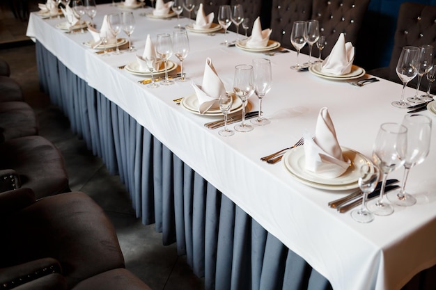 Sirviendo una mesa festiva en un restaurante Preparación de un banquete para unas vacaciones Materiales de decoración caros Platos para comida y bebida