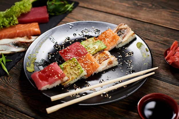 Sirviendo rollos de sushi y otra comida tradicional japonesa y asiática en una mesa