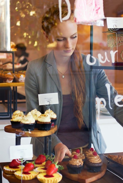 Sirviendo solo lo más fresco a sus clientes Fotografía de una atractiva joven que trabaja en una panadería