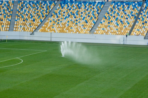 Sistema automático de irrigação de grama no estádio. Um campo de futebol em uma pequena cidade do interior