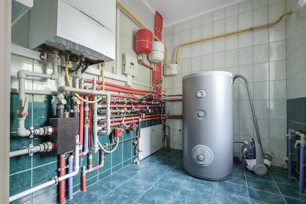 Foto sistema de calefacción en la sala de calderas sistema de suministro de agua y gas de la casa que mide la presión y controla la temperatura con sensores para caldera de gas con tuberías de hierro que se extienden desde ellos y un interruptor de presión