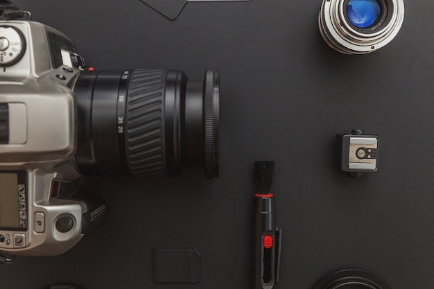 Sistema de cámara DSLR, kit de limpieza de cámara, lente y accesorio de cámara en mesa negra