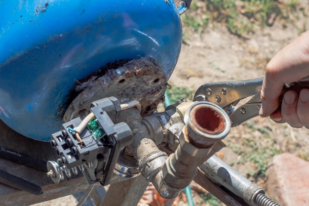 Sistema de água Um homem está reparando a unidade de distribuição de água de um tanque hidráulico em uma usina de água Desenroscando a válvula de retenção