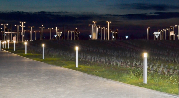 Sistema de iluminação moderno na cidade à noite, lanternas ao longo da estrada.