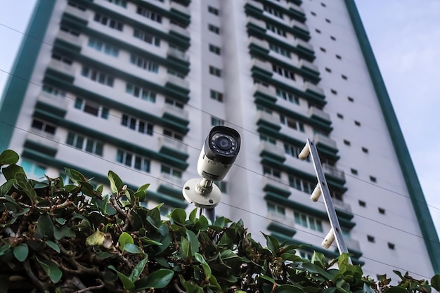 Foto sistema de segurança de condomínio residencial câmara de segurança e cerca elétrica com edifício no ba