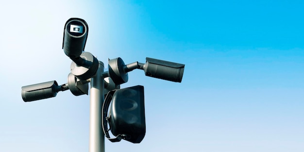 Sistema de vigilância de câmera de segurança CCTV público ao ar livre em visão panorâmica de fundo de céu azul com espaço de cópia