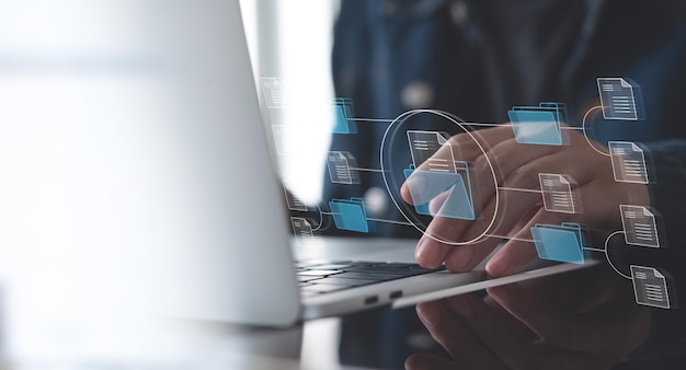 Sistema de gestión de documentos (DMS) que está siendo configurado por un consultor de TI que trabaja en una computadora portátil en la oficina Software para archivar, buscar y administrar archivos e información corporativos