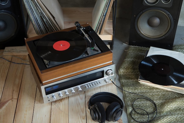 Foto sistema hifi com fones de ouvido amplificador de toca-discos e discos de vinil lp em uma sala de audição