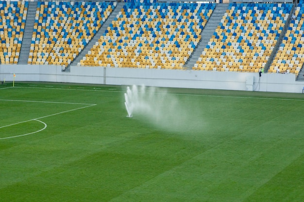 Sistema de riego automático de césped en el estadio. Un campo de fútbol, fútbol en una pequeña ciudad de provincias.