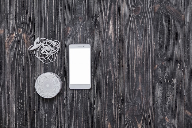 Sistema de sonido portativo con auriculares y pantalla en blanco de teléfono móvil