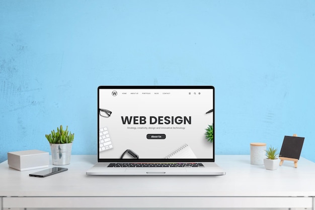 Site moderno da empresa de web design apresentado em um computador portátil mesa de trabalho moderna com parede azul