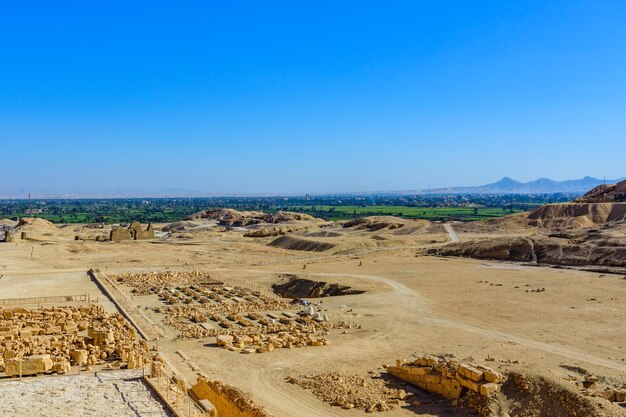 Sítio arqueológico perto do templo de Hatshepsut na paisagem verde de Luxor Egito em um fundo