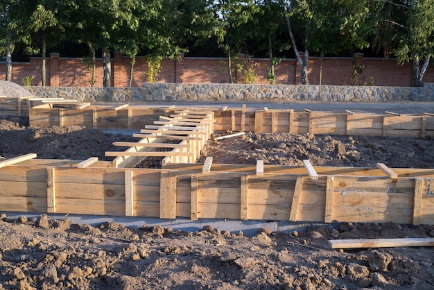 Sitio de cimentación de nuevos detalles de construcción y refuerzos con barras de acero y alambrón en cubiertas de madera que se preparan para el vertido de cemento