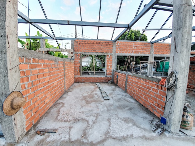 Foto sitio de construcción de la casa utilice ladrillos rojos como pared. con estructura de techo de acero pilar de hormigón.