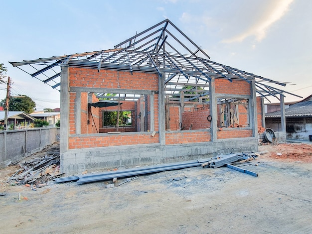 Foto sitio de construcción de la casa utilice ladrillos rojos como pared. con estructura de techo de acero pilar de hormigón.