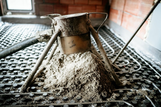 El sitio de construcción detalla la bomba de hormigón interior que trabaja en solera y calefacción por suelo radiante