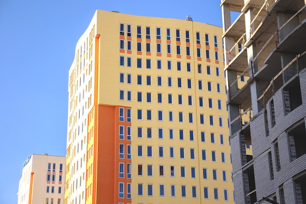 Sitio de construcción de edificios residenciales, vista desde el suelo. Foto de fondo de cielo azul claro