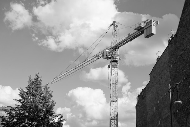 Sitio en construcción Grúa de construcción en cielo nublado Grúa para la construcción de edificios Construcción de edificios Adición de estructura a bienes inmuebles Construcción residencial o no residencial