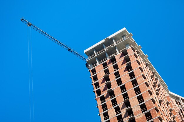 Sitio de construcción con grúa contra el cielo azul Construcción de un edificio de varios pisos