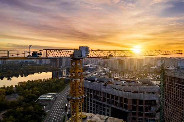 Sitio de construcción con grúas al atardecer Construcción de un edificio de apartamentos