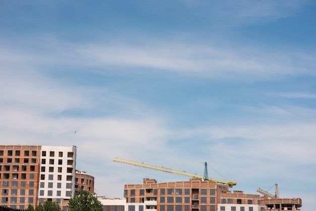 Sitio de construcción de grúas y edificios contra el cielo azul