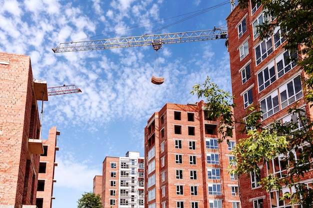 Foto sitio de construcción con grúas torre sobre un fondo de cielo azul