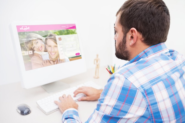 Sitio web de citas contra un hombre de negocios informal que trabaja en su escritorio