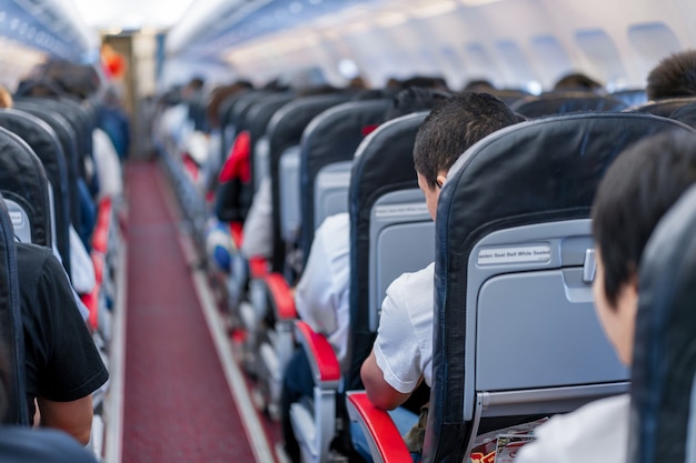 Sitze im Flugzeug und Passagiere sitzen alle Bereiche, die darauf warten, dass das Flugzeug von der Landebahn abhebt.