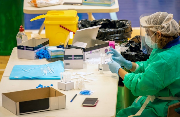 Sitzende Krankenschwester, die verschiedene Pflegeprodukte handhabt