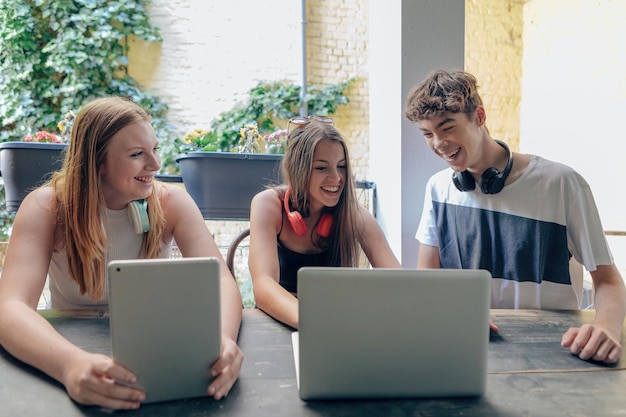 Foto sitzende teenager, die technologie verwenden