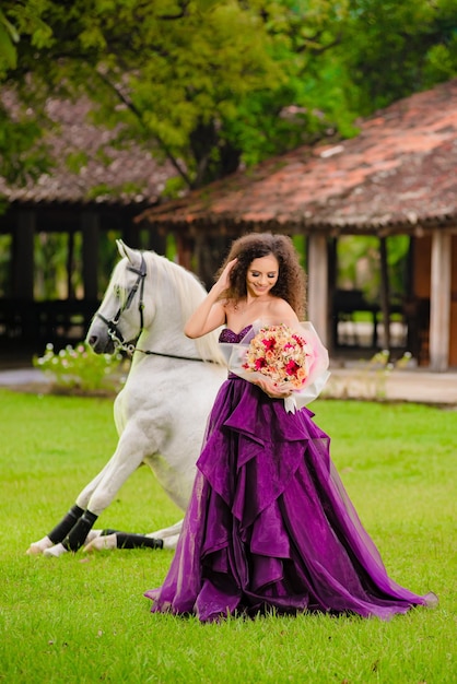 Foto sitzendes pferd und ein wunderschönes cowgirl auf der ranch